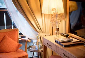 Maßgefertigte Inneneinrichtung aus Holz für ein Hotelzimmer mit Kommode, Sessel und indirekter Beleuchtung